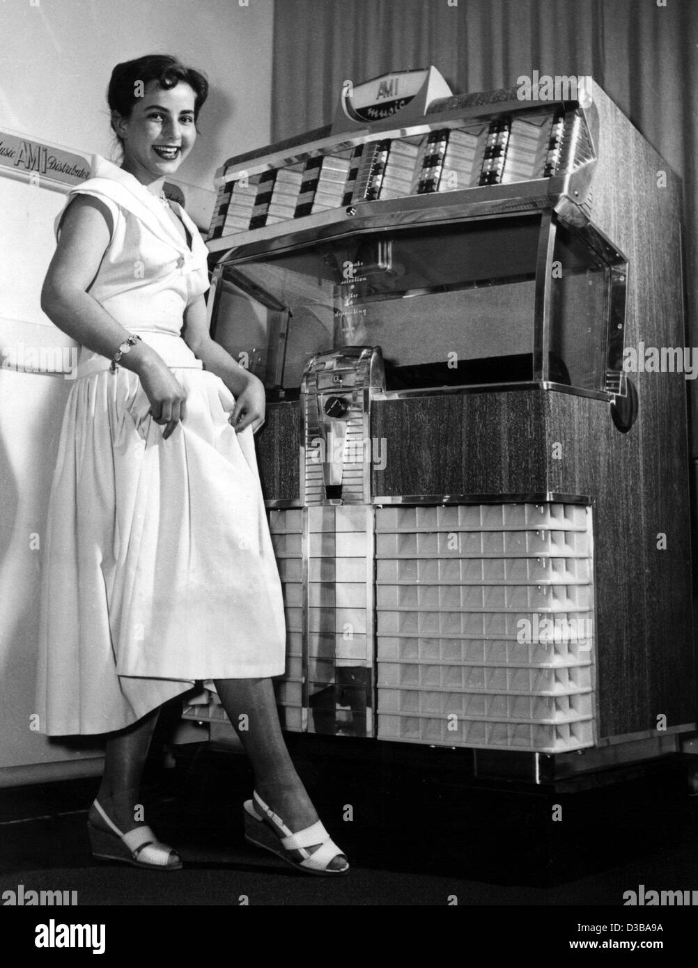 (Dpa file) - Una giovane donna sorridendo pone di fronte ad un musicbox a Amburgo, Germania Ovest, aprile 1961. Foto Stock