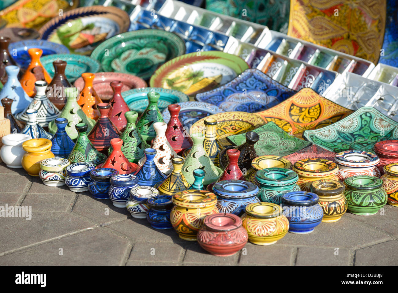 Gli ingredienti di base di una tagine , posacenere, piastre e altri souvenir marocchini sul display nel souk di Marrakech, Marocco. Foto Stock