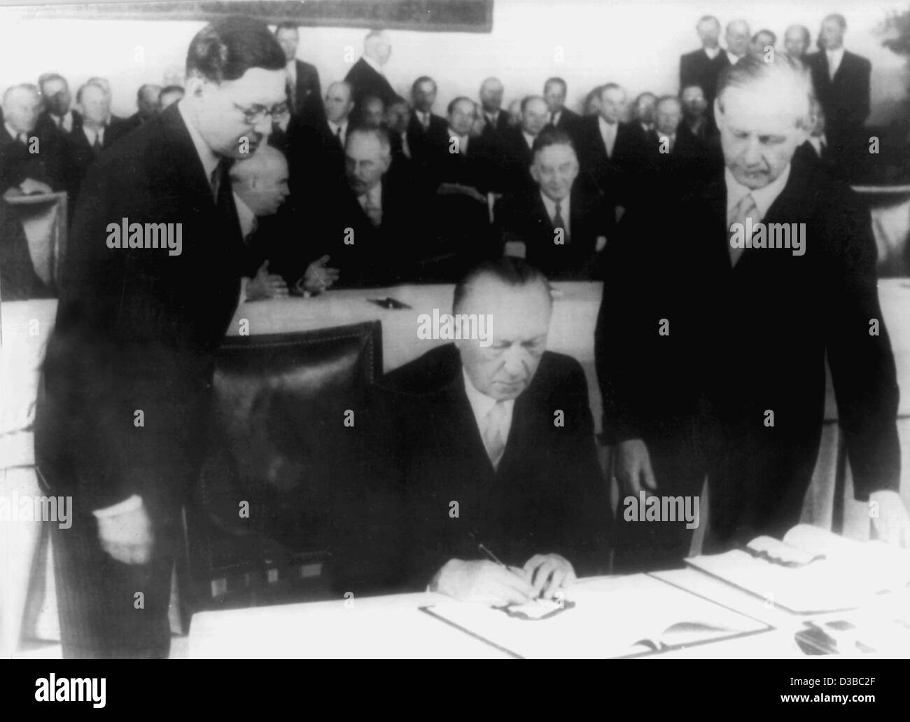 (Dpa file) - Konrad Adenauer, West il Cancelliere tedesco e il ministro degli Esteri, segni la Germania trattato in Occidente capitale tedesca di Bonn, 26 maggio 1952. Il trattato firmato con le Tre Potenze occidentali la Gran Bretagna, la Francia e gli Stati Uniti hanno garantito la piena sovranità per tutti interni e esteri di p Foto Stock