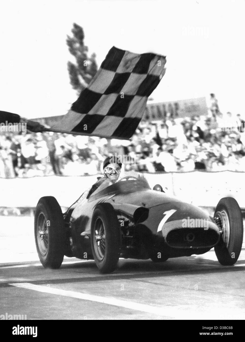 (Dpa file) - Argentine pilota di Formula Uno Juan Manuel Fangio taglia il traguardo del Gran Premio di Germania sul Nuerburgring corse ovviamente, Germania, 4 agosto 1957. Ha vinto il titolo di campione del mondo per la quinta volta. Foto Stock