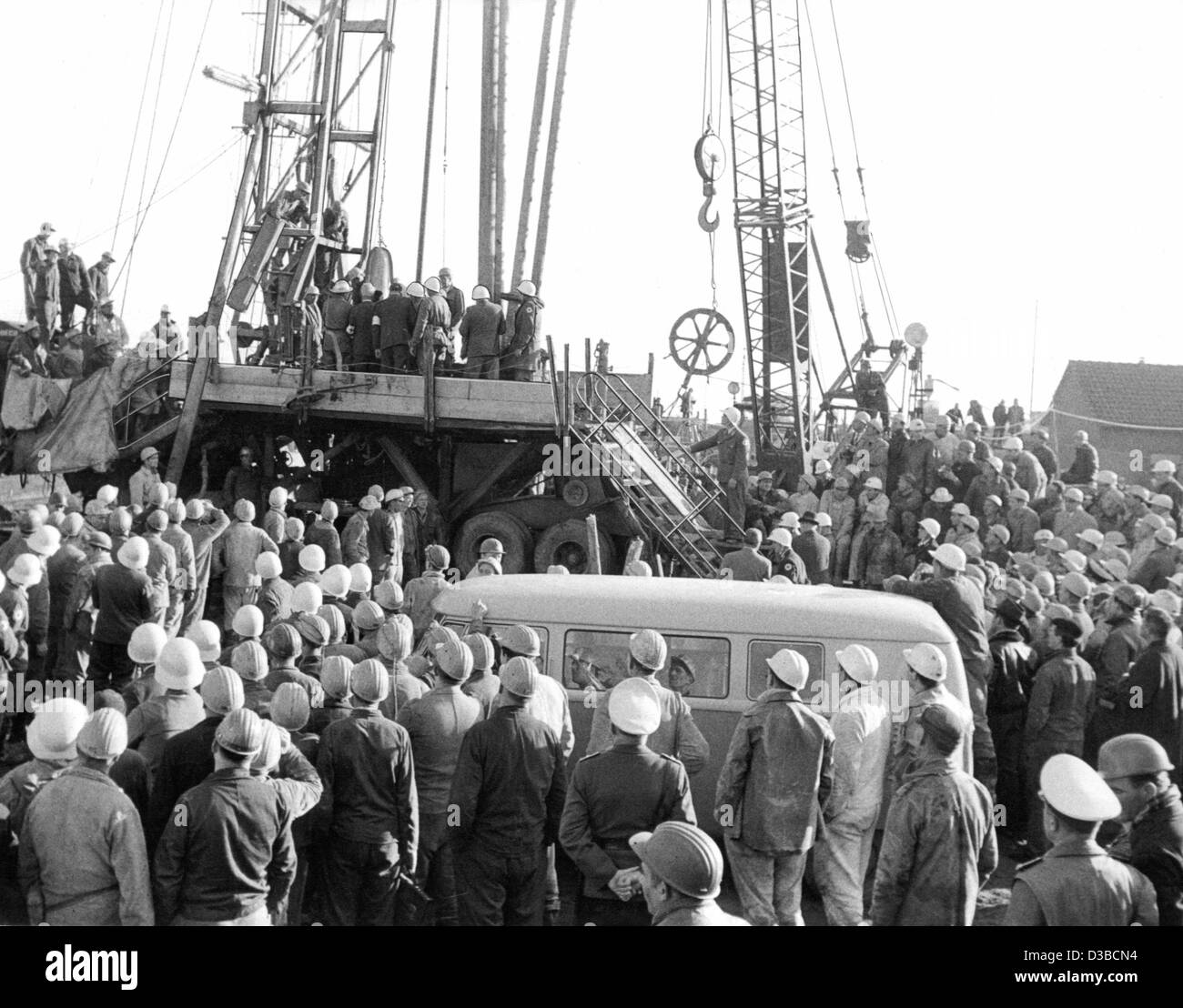 (Dpa file) - 500 minatori testimone diretto le operazioni di salvataggio presso la piattaforma di perforazione derricks presso la miniera di 'Mathilde' in Lengede, Germania Ovest, 7 novembre 1963. Il 24 ottobre un burst dam si era allagata la miniera e intrappolata 129 minatori; 29 uomini morirono, 86 uomini evasi entro un breve periodo di tempo, 3 uomini sono stati Foto Stock