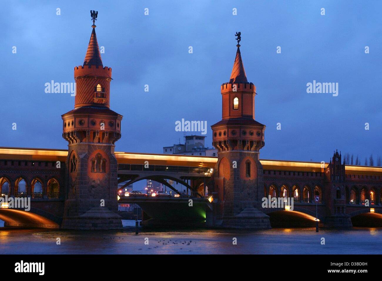 (Dpa) - Un treno metropolitano aziona attraverso il ponte Oberbaum a Berlino, 28 gennaio 2003. Il ponte che attraversano il fiume Sprea è stato originariamente costruito come un ponte di legno nel 1724 e fu per secoli il più lungo ponte a Berlino. Fu ricostruita con le sue due torri e un viadotto per il primo ele Foto Stock