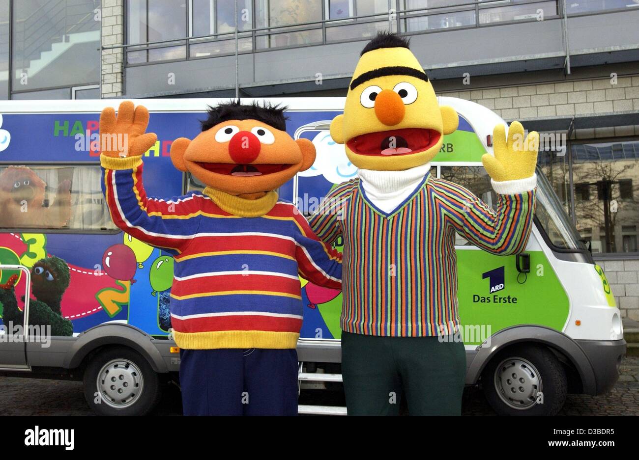 (Dpa) - Ernie (L) e Bert (R) stand di fronte al sesamo Street tour bus e agitare le mani in Amburgo, 27 novembre 2002. La prima stagione della edizione tedesca è stato trasmesso nel gennaio 1973. In occasione del trentesimo compleanno di Sesame Street, Ernie e Bert visita celebrità su un beneficio per Foto Stock