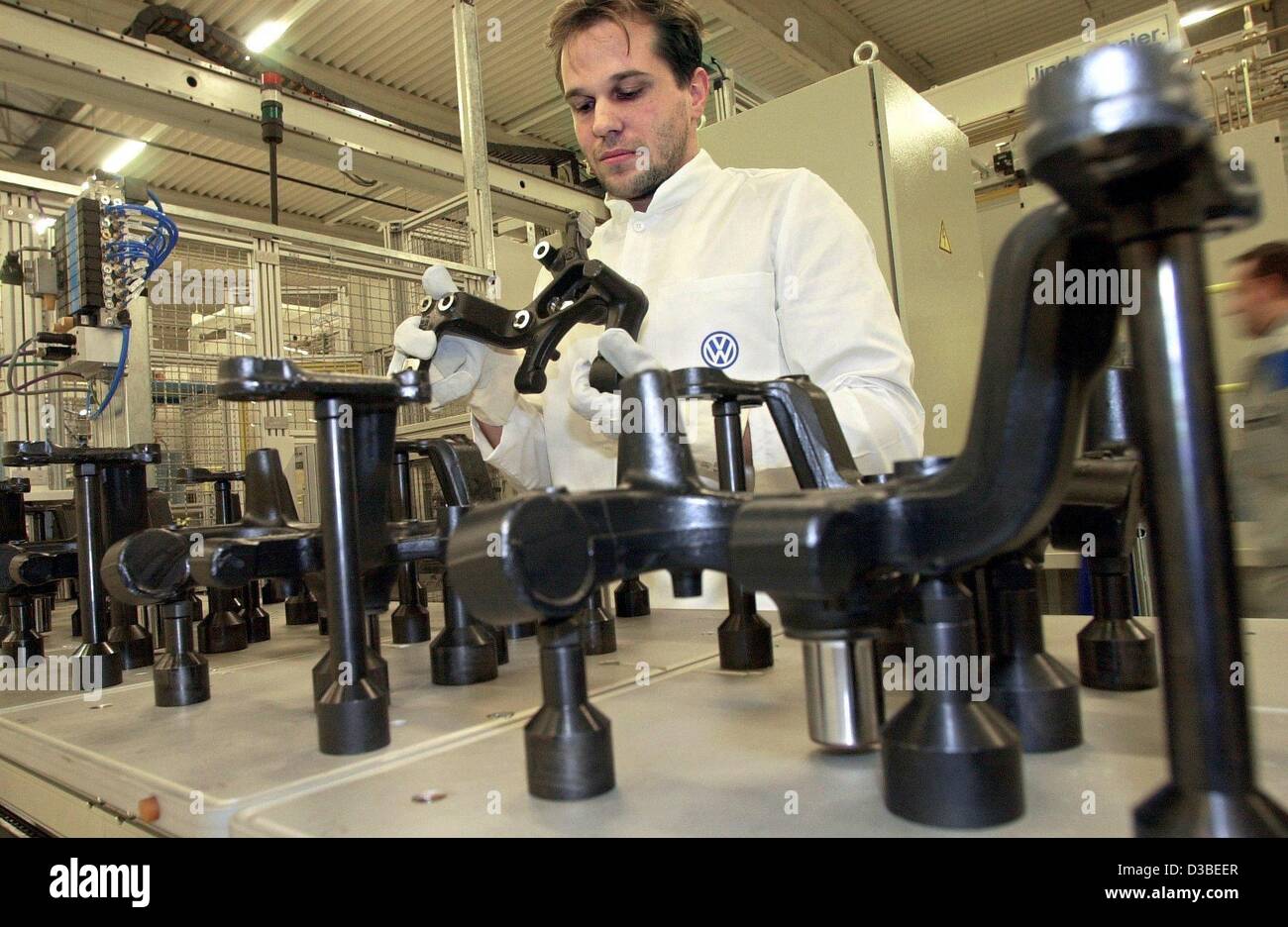 (Dpa) - Una Volkswagen dipendente è di controllare le linee della ruota per il nuovo modello VW Touran nel nuovo stabilimento di Braunschweig, Germania, 13 gennaio 2003. L'edificio è 30.000 metri quadrati ed è costato 50 milioni di euro. È stato ufficialmente messo in funzione il 14 gennaio 2003. Il Touran è un furgone compatto b Foto Stock