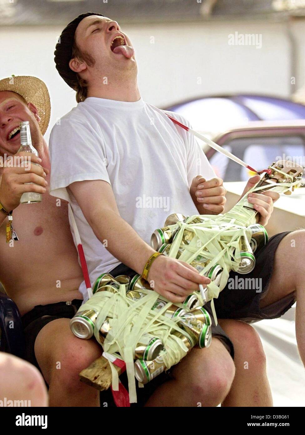 (Dpa) - gli appassionati di musica chill out al sole e suonare la chitarra falsa fatta di lattine di birra presso il leggendario 'Rock am Ring Festival di musica al Nuerburgring, Germania, il 7 giugno 2003. 'Rock Am Ring' insieme con 'Rock im Park", che si svolge al tempo stesso a Norimberga, il conteggio per il più grande aria aperta musi Foto Stock