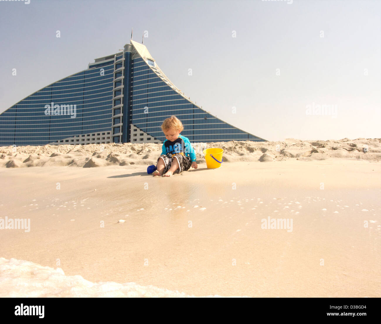 Ragazzo gioca sulla spiaggia di fronte al Jumeirah Beach Hotel a Dubai EMIRATI ARABI UNITI Foto Stock