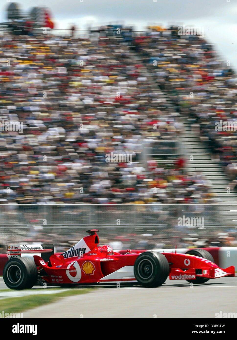 (Dpa) - tedesco di Formula Uno del campione del mondo in carica Michael Schumacher (Ferrari) razze passato la tribuna con gli spettatori sul Circuito Gilles Villeneuve formula one racing via durante il Gran Premio del Canada a Montreal, Canada, 15 giugno 2003. Michael Schumacher vince la gara e conduce in standin globale Foto Stock