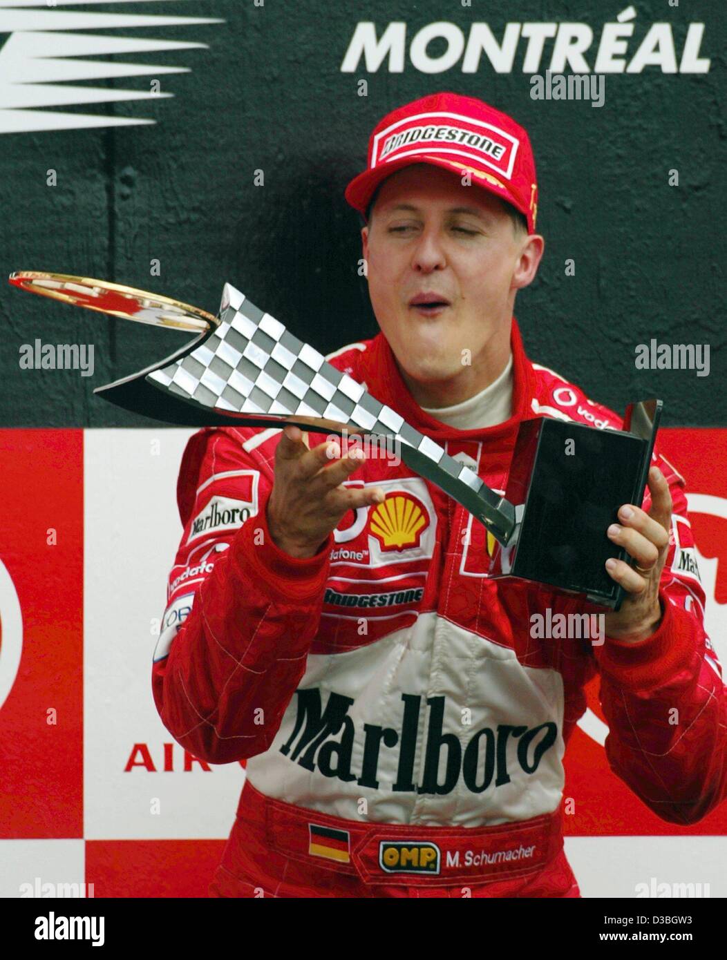 (Dpa) - tedesco di Formula Uno del campione del mondo in carica Michael Schumacher (Ferrari) detiene il trofeo racing nelle sue mani dopo aver vinto il Gran Premio del Canada durante la cerimonia di premiazione che si terrà sul circuito Gilles Villeneuve formula one racing via a Montreal, Canada, 15 giugno 2003. Michael Schumacher vince la gara Foto Stock