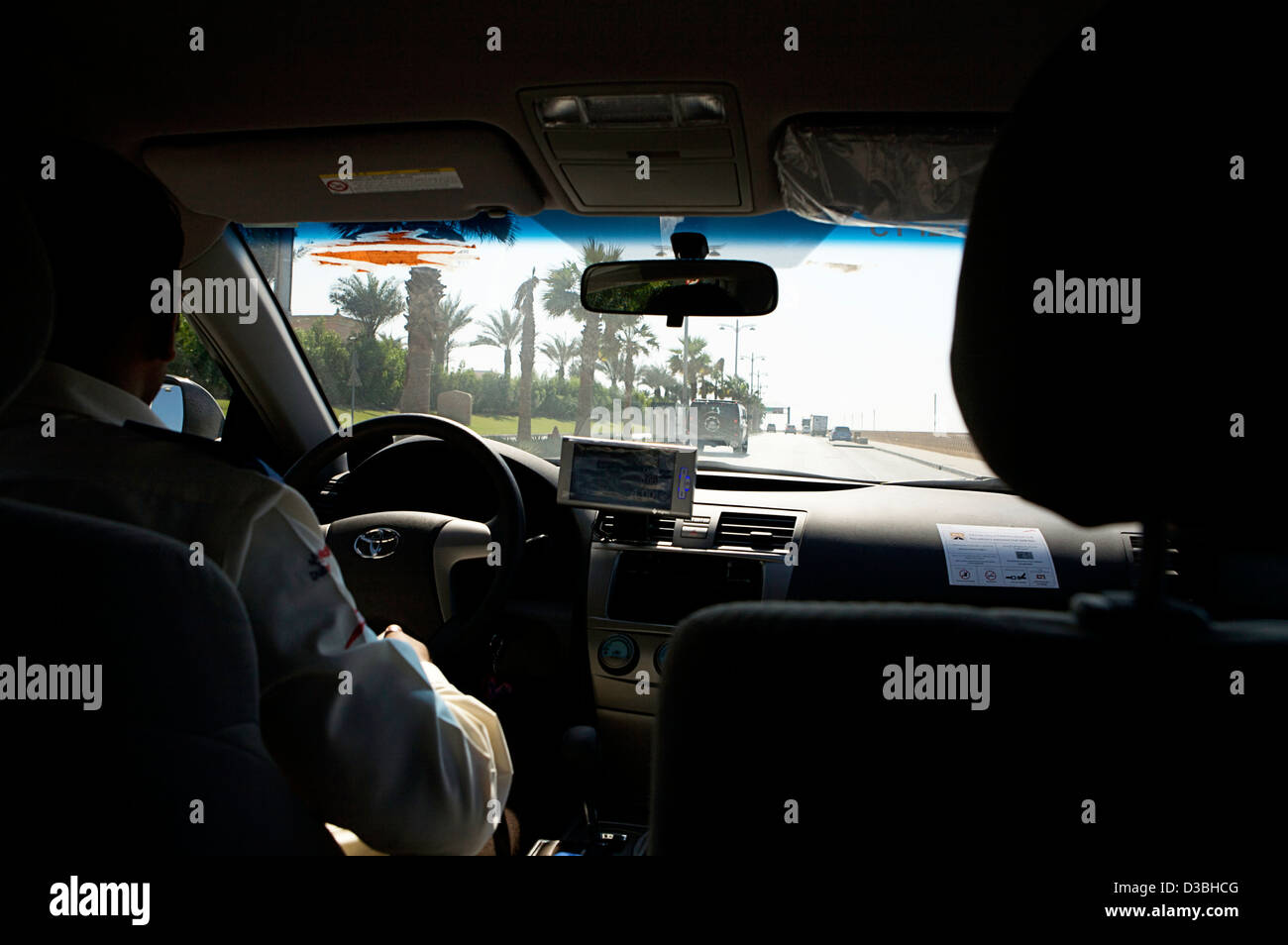 Taxi driver alla guida della sua cabina in Dubai Emirati Arabi Uniti con il meteor in esecuzione come si vede dalla backseat Foto Stock