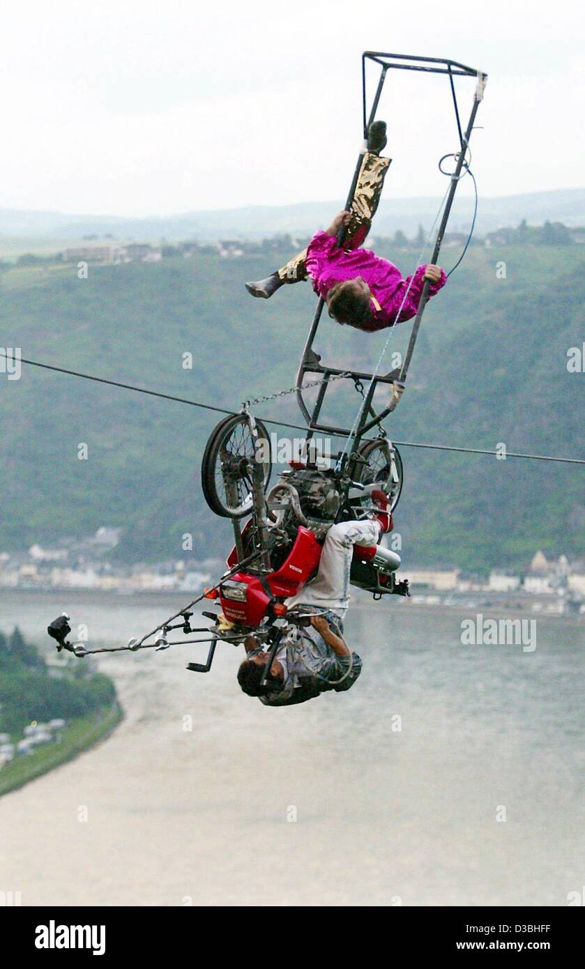 (Dpa) - La mostra fotografica di filo alto artista Johann Traber e suo figlio Pietro che aziona il motociclo, come hanno stabilito un nuovo record mondiale di eseguire 14 torsioni sul filo alto, che spazia dal rock Loreley attraverso il fiume Reno, vicino a St. Goar, Germania, 8 giugno 2003. Facendo oscillare il trapezio pesantemente Tr Foto Stock