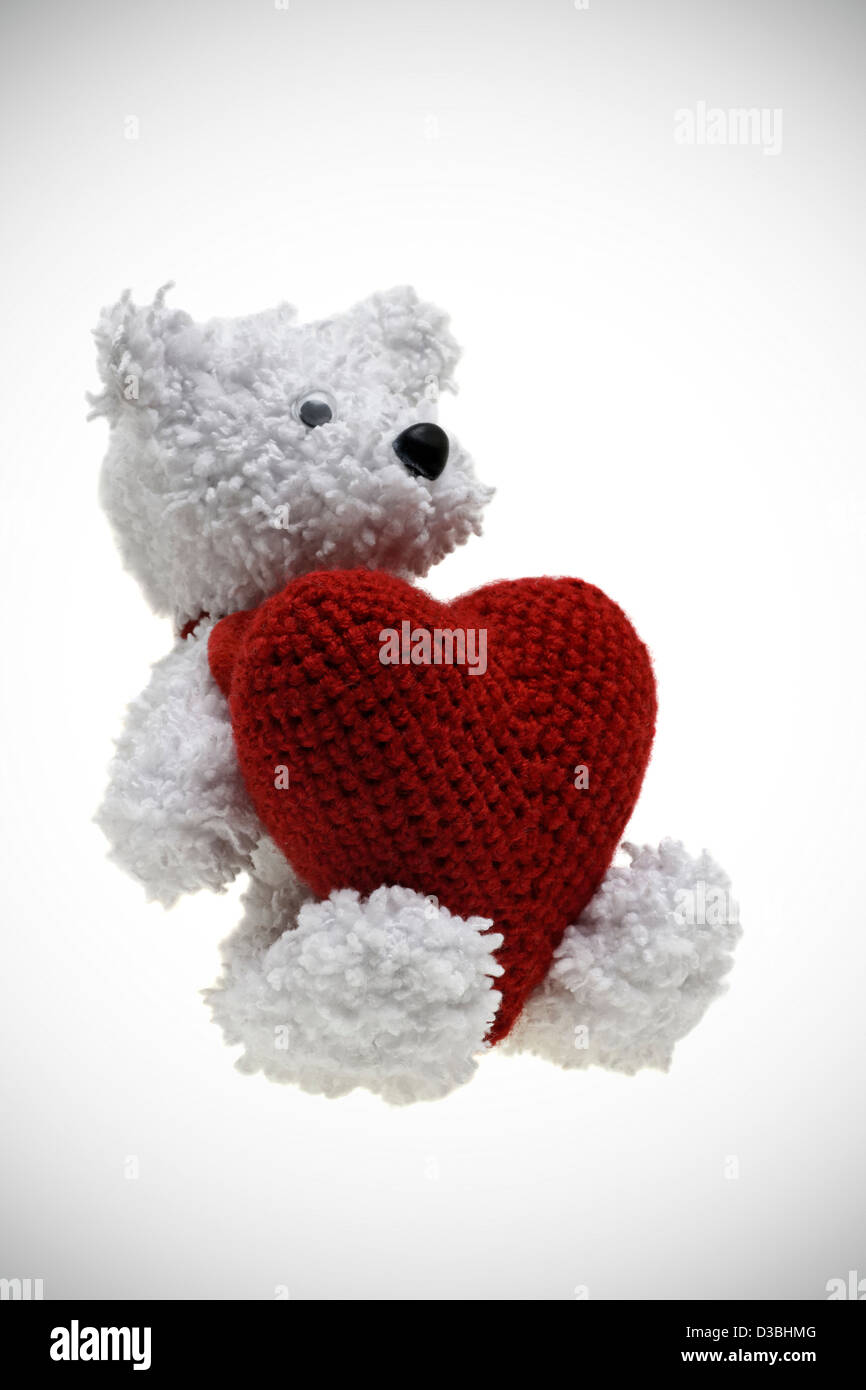 Bianco maglia bear holding leggere il cuore. Isolato su sfondo bianco Foto Stock