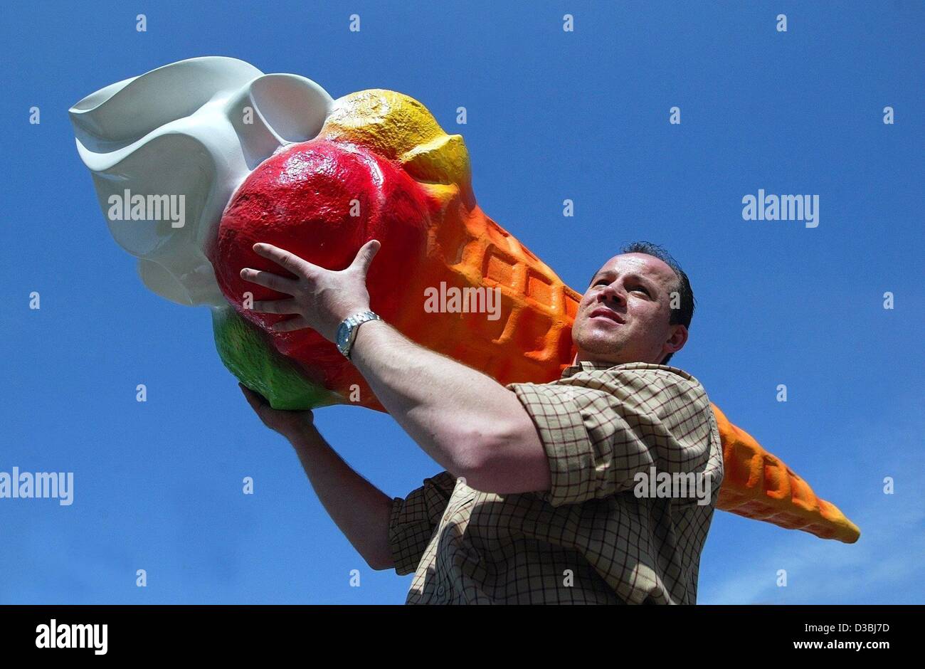 (Dpa) - Italiano gelateria proprietario Antonio Toscani porta un sovradimensionamento di repliche di un gelato sulla sua spalla, in Markt Koesching, Germania, 16 aprile 2003. Foto Stock