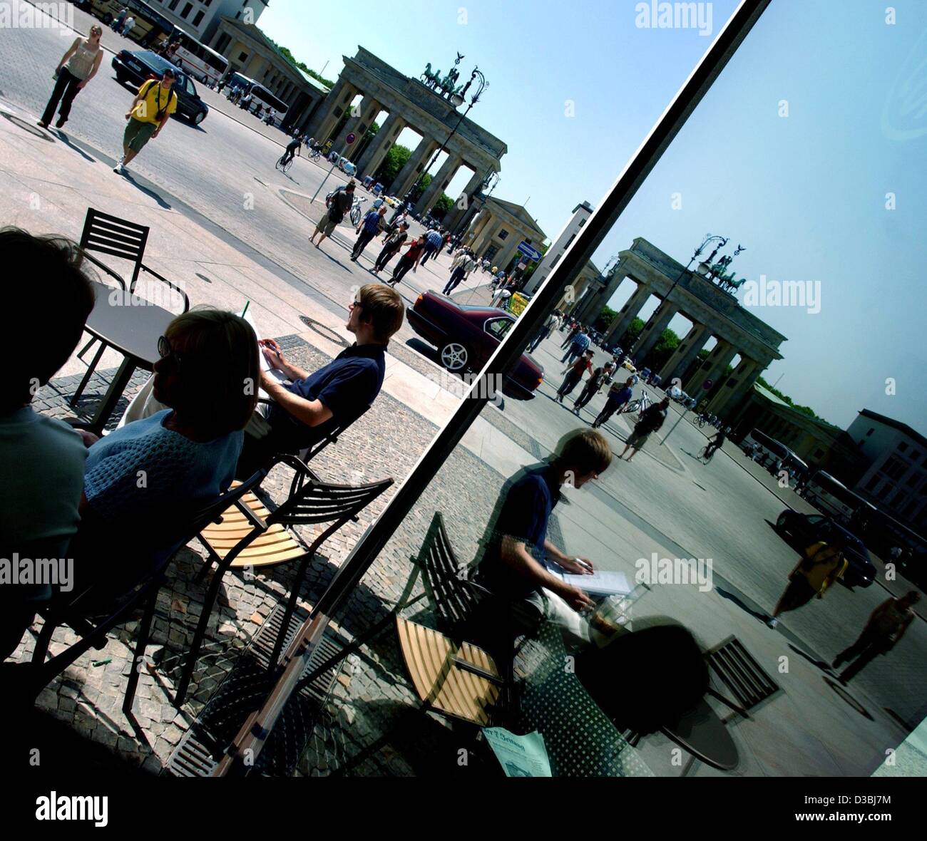 (Dpa) - i clienti di un cafè sul marciapiede sedersi fuori, leggere i giornali e sono riflesse nella finestra di visualizzazione del cafè presso la Pariser Platz a Berlino, il 5 maggio 2003. Foto Stock