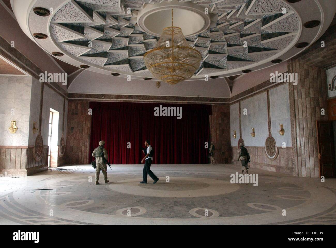 (Dpa) - US Marines a piedi attraverso il cinema all'interno di Saddam Hussein la ex residenza estiva nel nord della città irachena di Tikrit, 14 aprile 2003. Di Tikrit, la città natale di Saddam, fu l'ultima roccaforte del suo regime la cui caduta avrebbe segnato la fine effettiva della guerra. Foto Stock