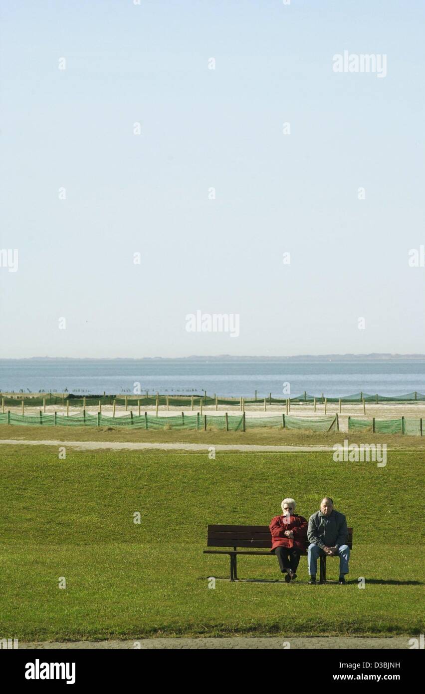 (Dpa) - Una coppia di anziani seduti su una panchina e godervi il sole, a Wangerooge, Germania settentrionale, 21 marzo 2003. Foto Stock