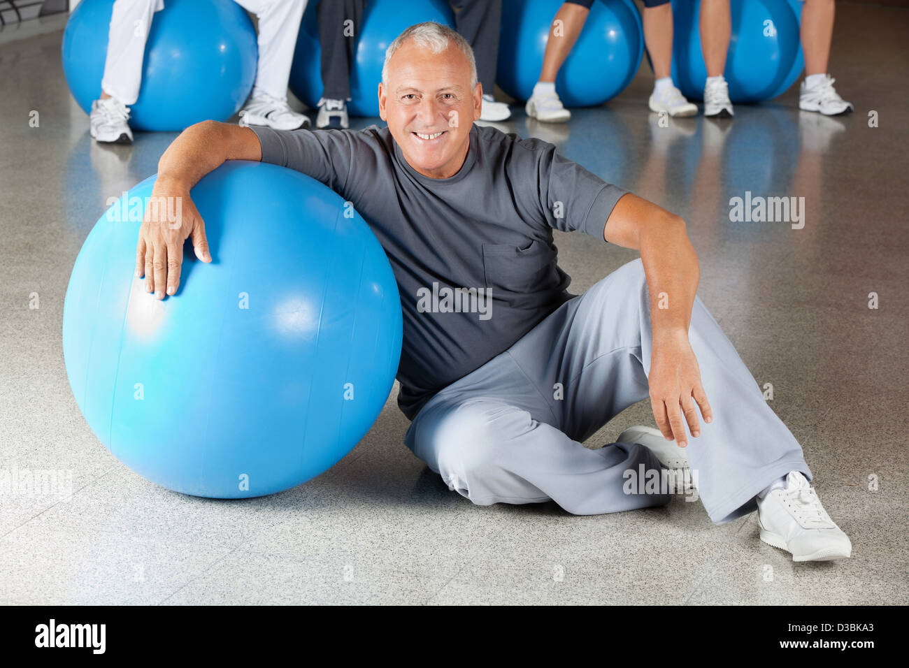 Felice l'uomo senior con palla nel centro fitness Foto Stock