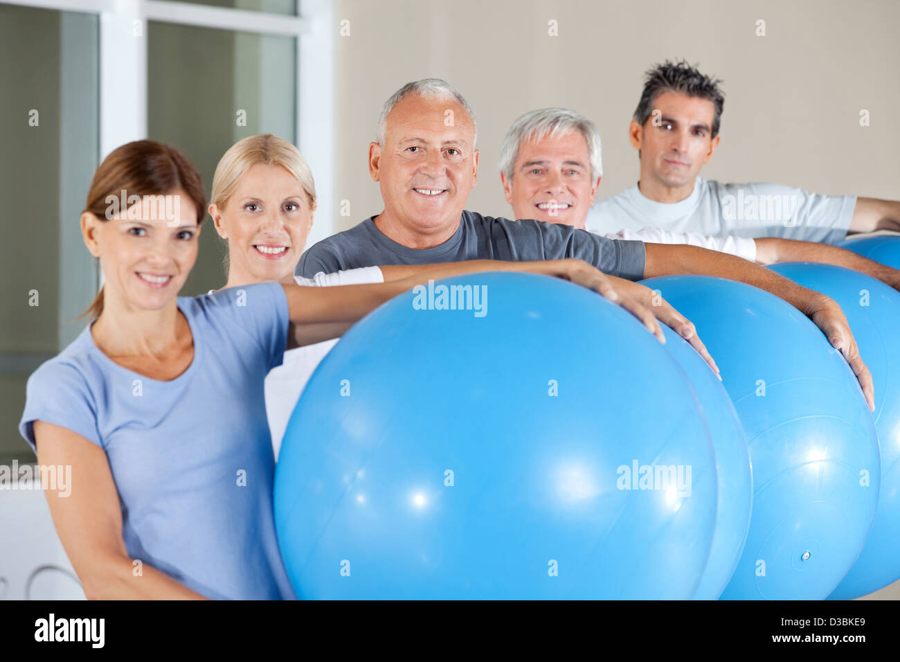 Felice dei cittadini anziani azienda palestra Blu sfere nel centro fitness Foto Stock