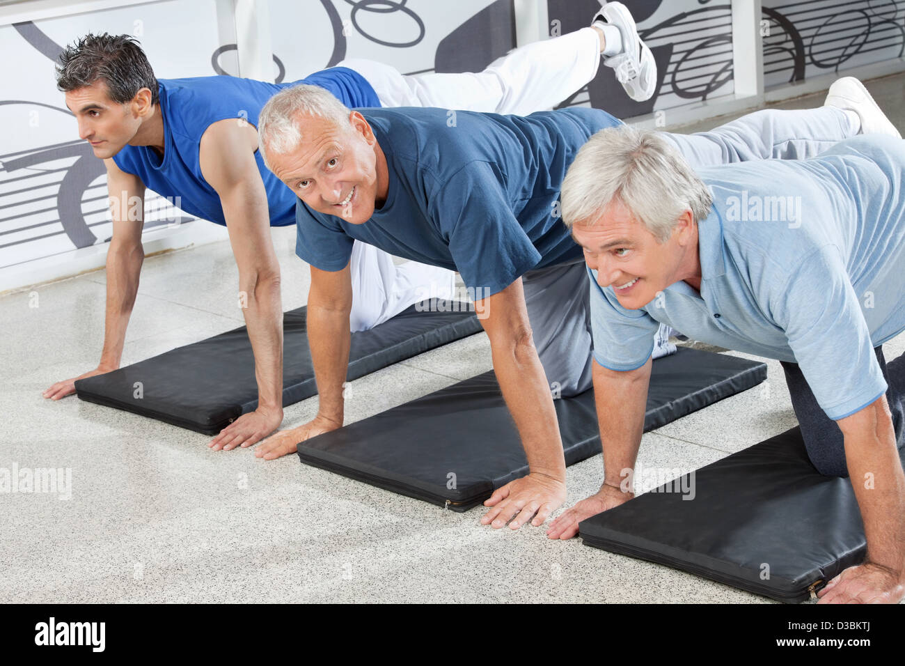 Tre cittadini senior di formazione insieme nel centro fitness Foto Stock