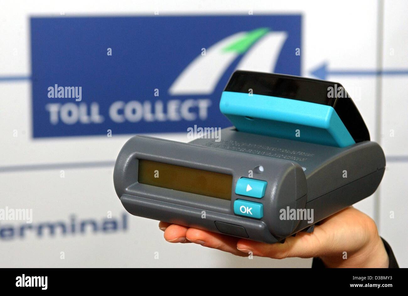 (Dpa) - Un dispositivo di acquisizione dati del carrello pedaggi è visto di fronte il logo della compagnia Toll Collect GmbH, Berlino, 20 maggio 2003. La società privata sarà responsabile per mettere il pedaggio di ponti e di operare la riscossione dei pedaggi. Inizia il 1 settembre 2003, le merci pesanti veh Foto Stock