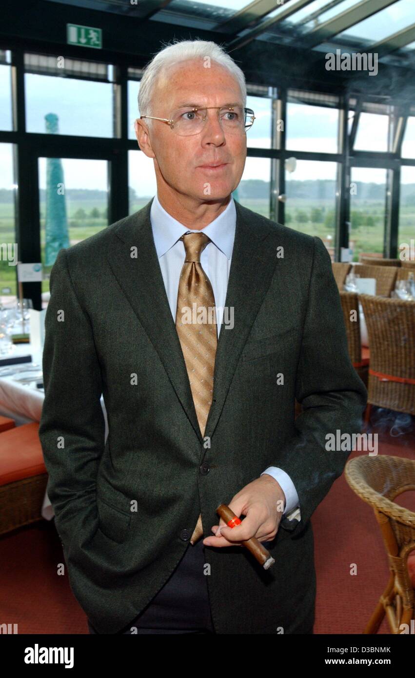 (Dpa) - Tedesco leggenda del calcio Franz Beckenbauer, presidente del comitato organizzatore dei Campionati del Mondo di Calcio 2006 e presidente del club di calcio Bayern Monaco, fuma un sigaro presso il Golf & Country Club in Brunstorf, Germania, 18 maggio 2003. Foto Stock