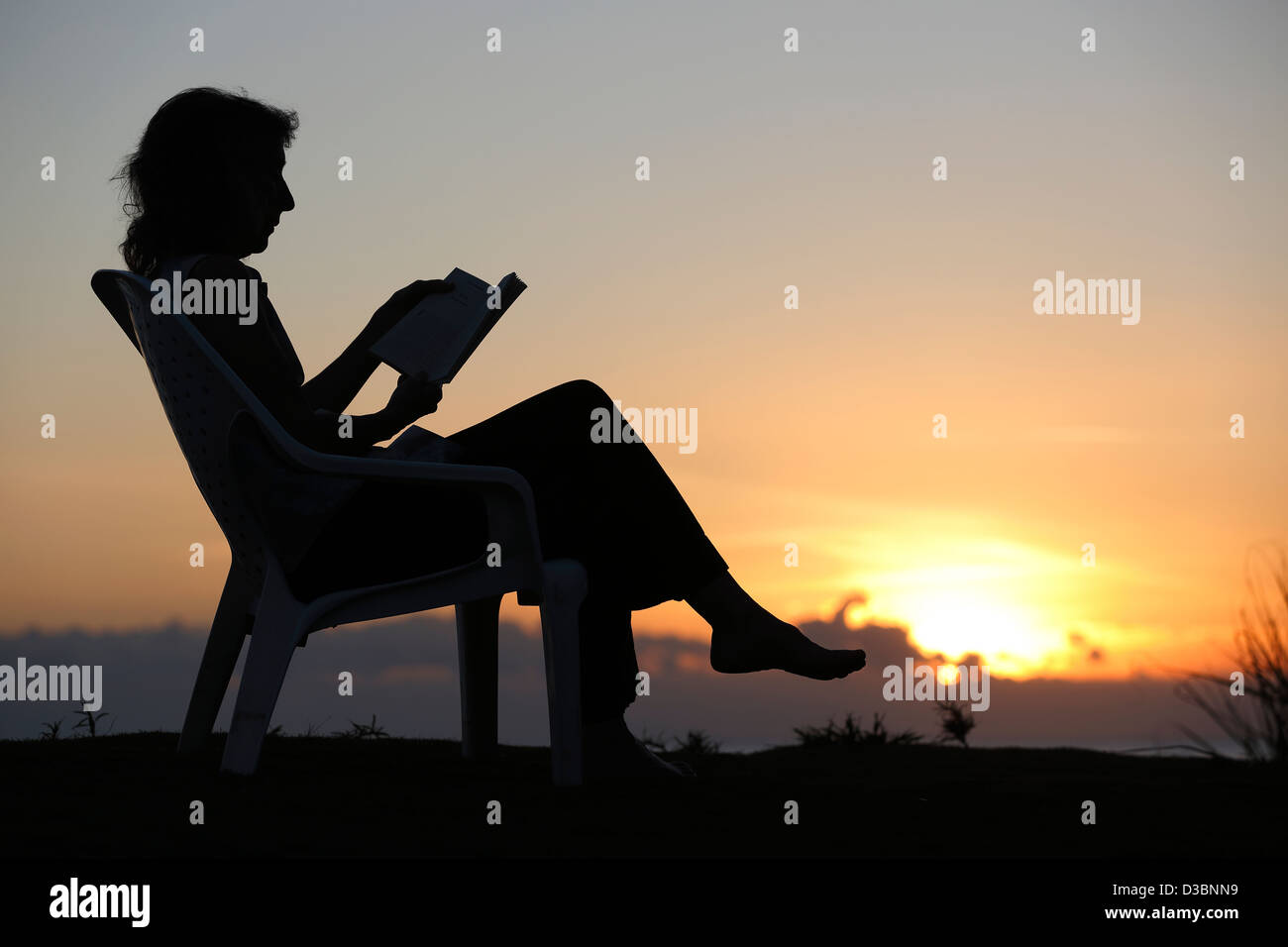 Lettura della donna al tramonto, las Lajas, Panama Foto Stock