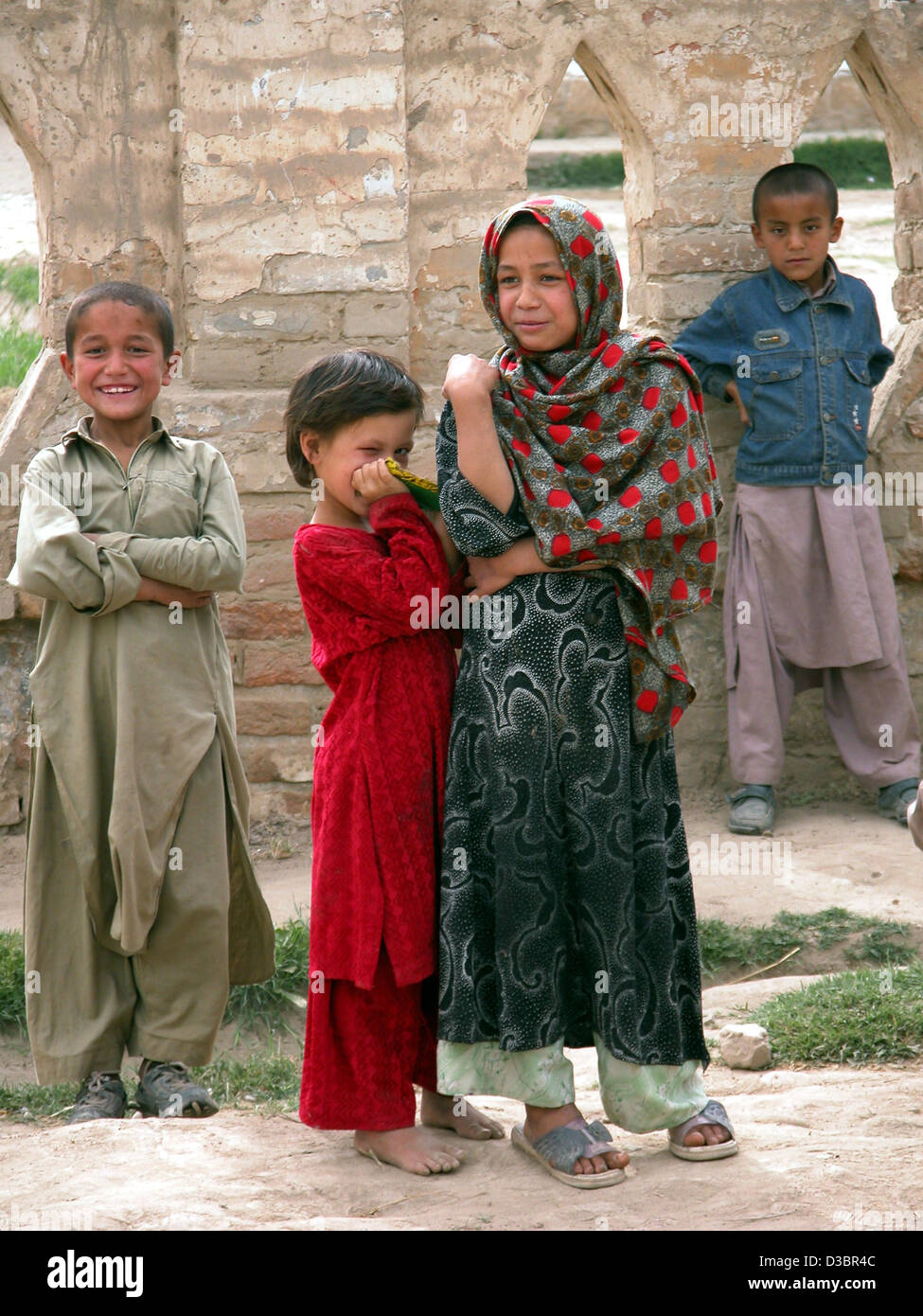 (Dpa) - Un piccolo gruppo di giovani bambini indossare abiti tradizionali si riuniscono per curiosamente guardare al fotografo di Eman Saheb, Afghanistan, 21 aprile 2004. Foto Stock