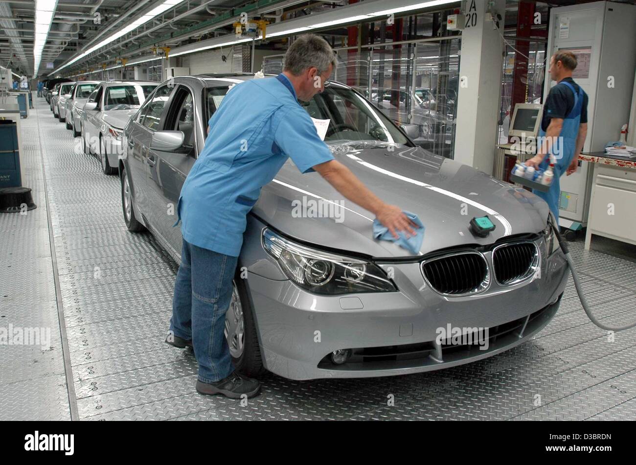 (Dpa) - Un dipendente della BMW lucidi di una vettura del nuovo modello fiver gamma in BMW impianto di assemblaggio in Dingolfing (Germania), 1 ottobre 2003. La pianta che assmbles le vetture per la fiver e sette modelli della gamma, festeggia il suo trentesimo anniversario. Lo stabilimento impiega 23.000 membri del personale ed è secondo Foto Stock