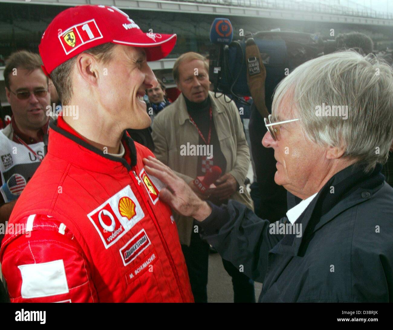 (Dpa) - responsabile britannico di formula one racing federation Bernie Ecclestone (R) e tedesco di Formula Uno del campione del mondo in carica Michael Schumacher parlare con ciascun altro e sorridere di fronte dei giornalisti sulla pista di giorni prima di iniziare la formula uno di noi Gran Premio di Indianapolis, Stati Uniti d'America, 26 settembre 200 Foto Stock