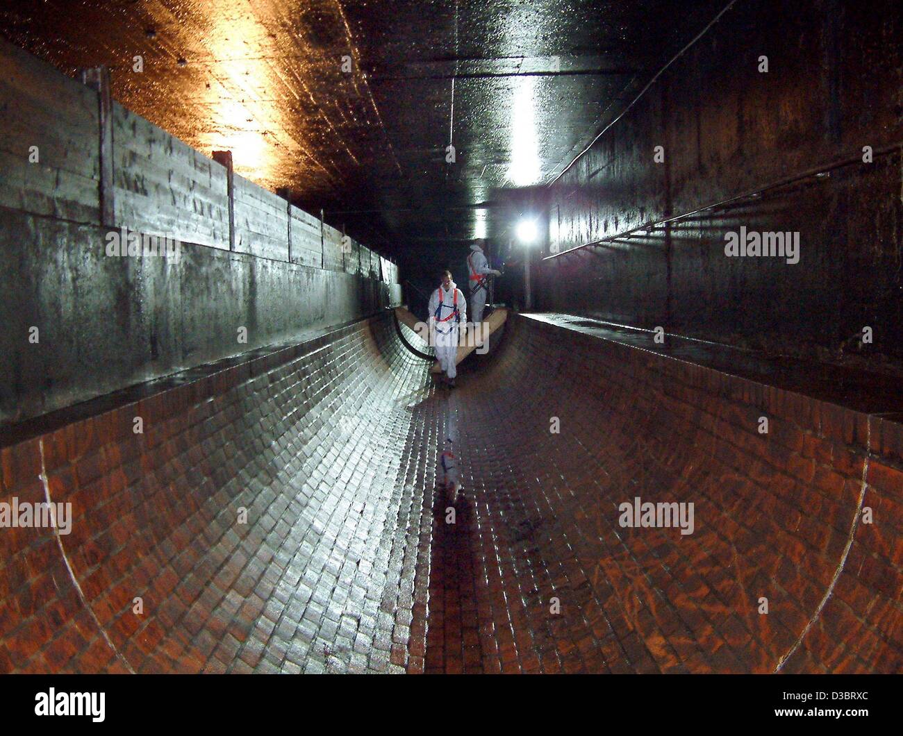 (Dpa) - visitatori a piedi attraverso un tubo del sistema fognario con un diametro di 3 metri, in Hannover, 8 maggio 2003. Hannover ha uno dei più grandi sistemi fognari in Germania con una lunghezza di 2.500 km. Circa il 8 per cento della 110 anno vecchio sistema è accessibile. Foto Stock
