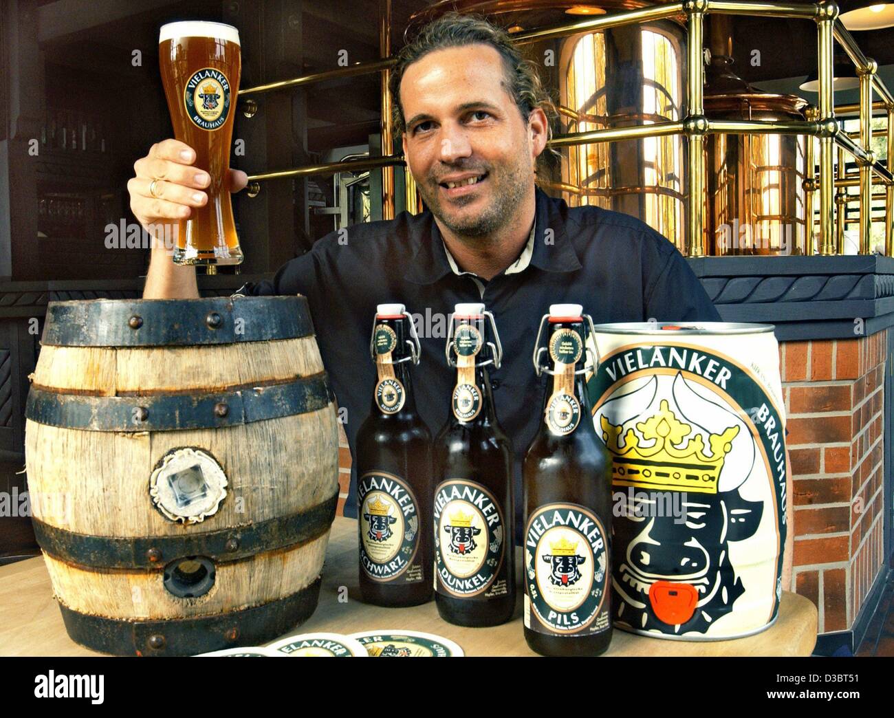 (Dpa) - Il CEO della birreria Vielanker pone con una fresca birra spillata, bottiglie di birra e un barile in birrificio Vielank, Germania, 21 agosto 2003. Il pub inaugurato un anno fa, la produzione di birra la propria quattro tipi di birra. Foto Stock