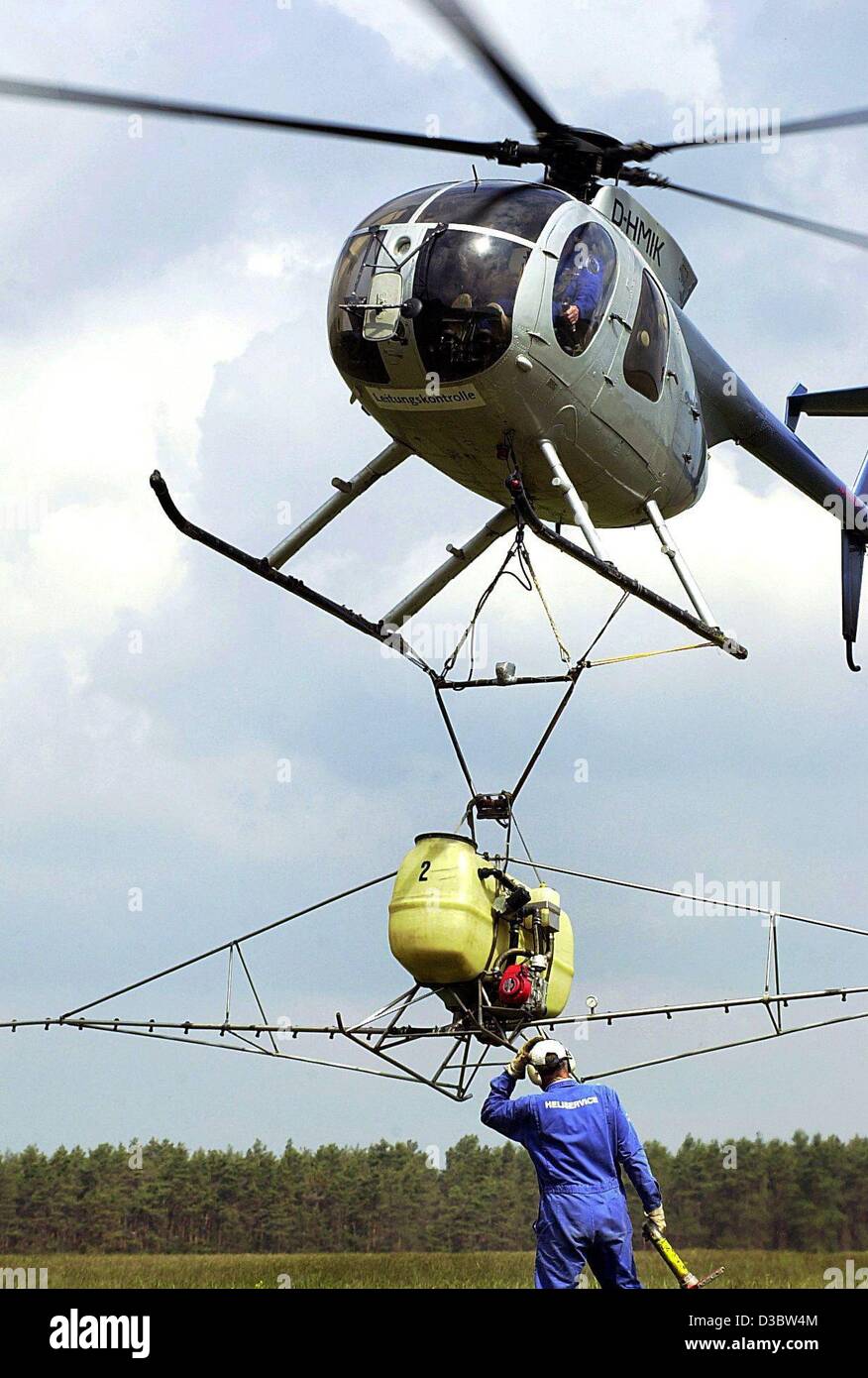 (Dpa) - un elicottero del tipo HU-500 abbassa il suo volo per ricaricare il suo serbatoio con pesticidi per irrorazione delle colture in Damsdorf, Germania, 14 maggio 2003. Foto Stock