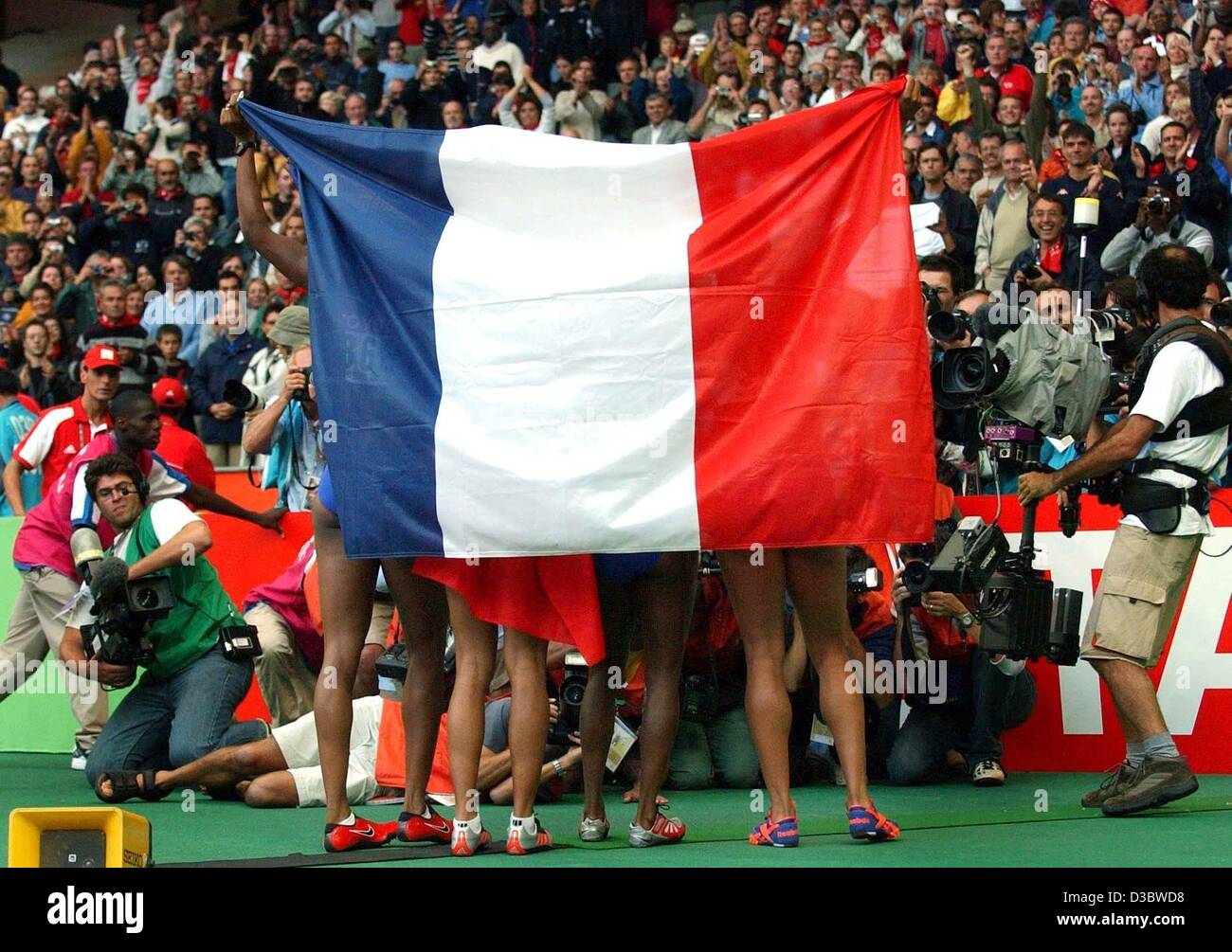 (Dpa) - Le guide del francese 4x100 m donne il relè jubilate e posare per i fotografi con la loro bandiera nazionale in occasione della IX IAAF Atletica Campionati del Mondo allo Stade de France di Parigi, 30 agosto 2003. Il quartetto francese ha vinto l'evento clocking 41.78 secondi. Foto Stock