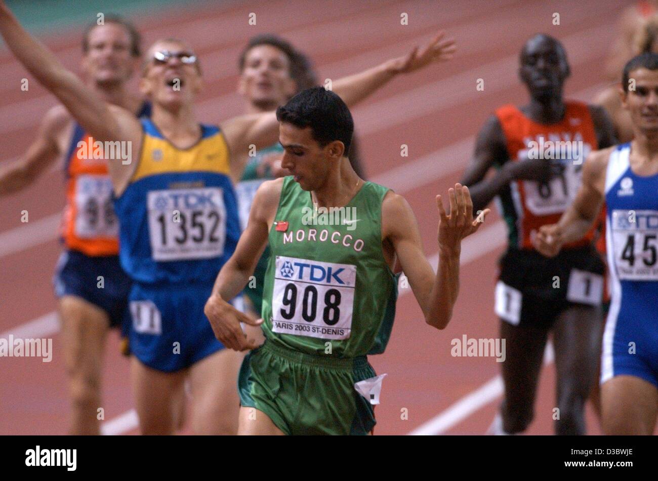 (Dpa) - Il vincitore del uomini 1.500 m caso del Marocco Hicham El Guerrouj, imita di suonare una chitarra per celebrare la sua vittoria in occasione della IX IAAF Atletica Campionati del Mondo allo Stade de France di Parigi, 27 agosto 2003. Dietro di lui (da L:) Olandese Liefers Gert-Jan (7°), ucraino Ivan HESHKO (3rd) Foto Stock
