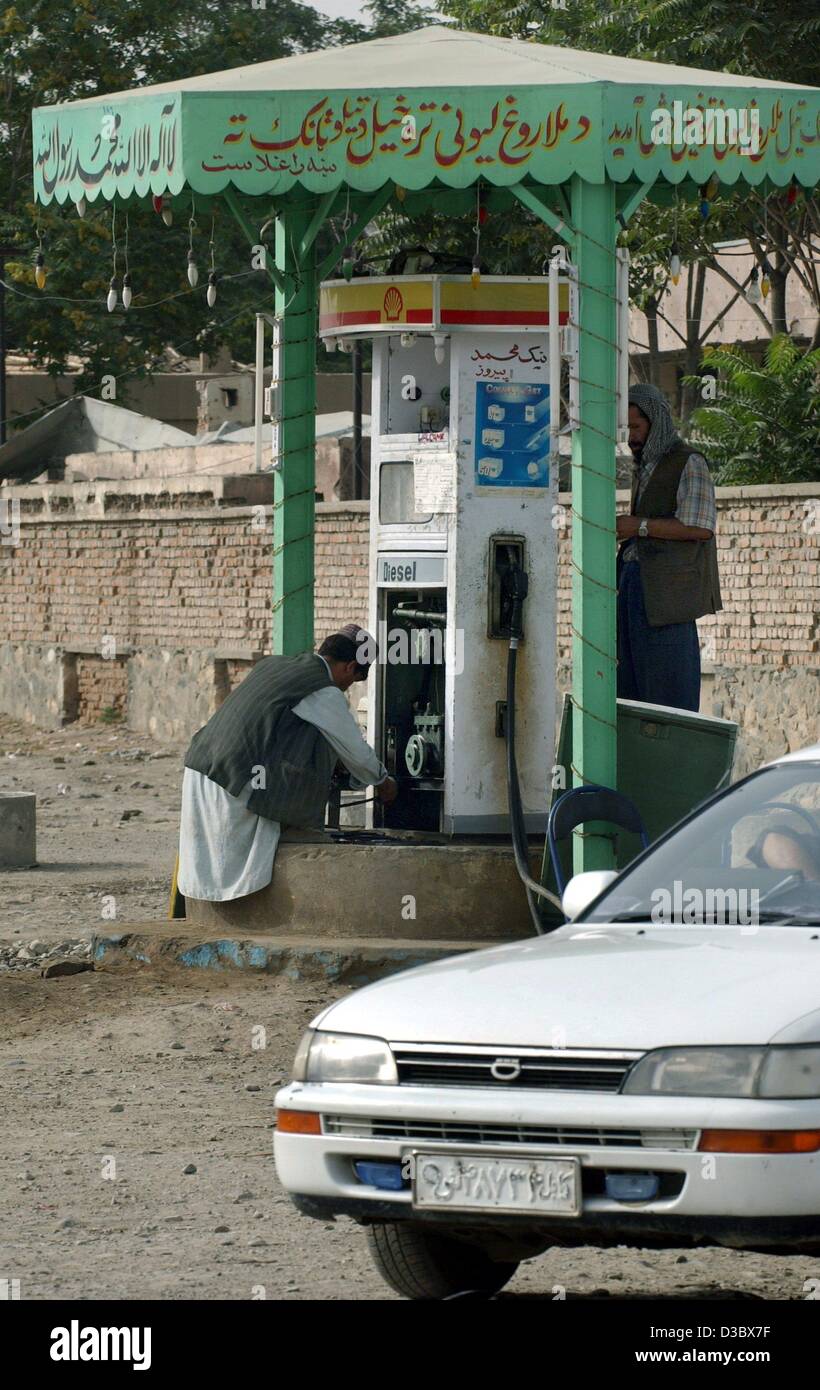 (Dpa) - Un auto afgano combustibili driver la sua auto in una stazione di rifornimento nel centro di Kabul, Afghanistan, 4 agosto 2003. Per la maggior parte afghani a possedere una vettura rimane un sogno lontano. La vita quotidiana a Kabul è ancora dominato dalla povertà. Foto Stock