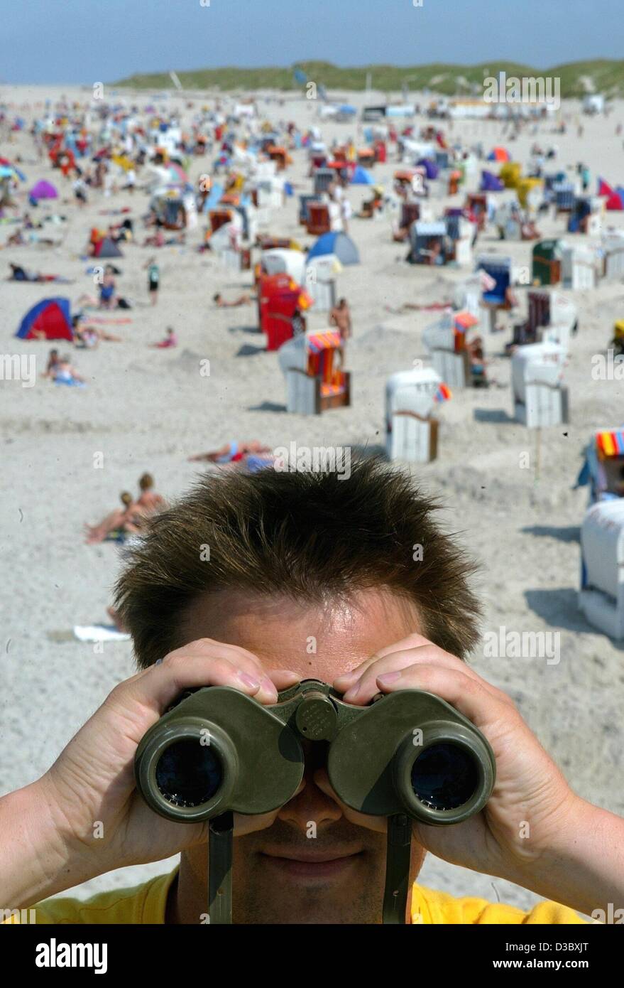 (Dpa) - un bagnino guarda attraverso il suo binocolo sulla spiaggia dell'isola Amrum, Germania, 6 agosto 2003. Temperature in Germania sono state appena strettamente minore del tempo di tutti i record di tedesco di 40,2 gradi centigradi e meteo dello scambiatore di calore non è in vista. Foto Stock