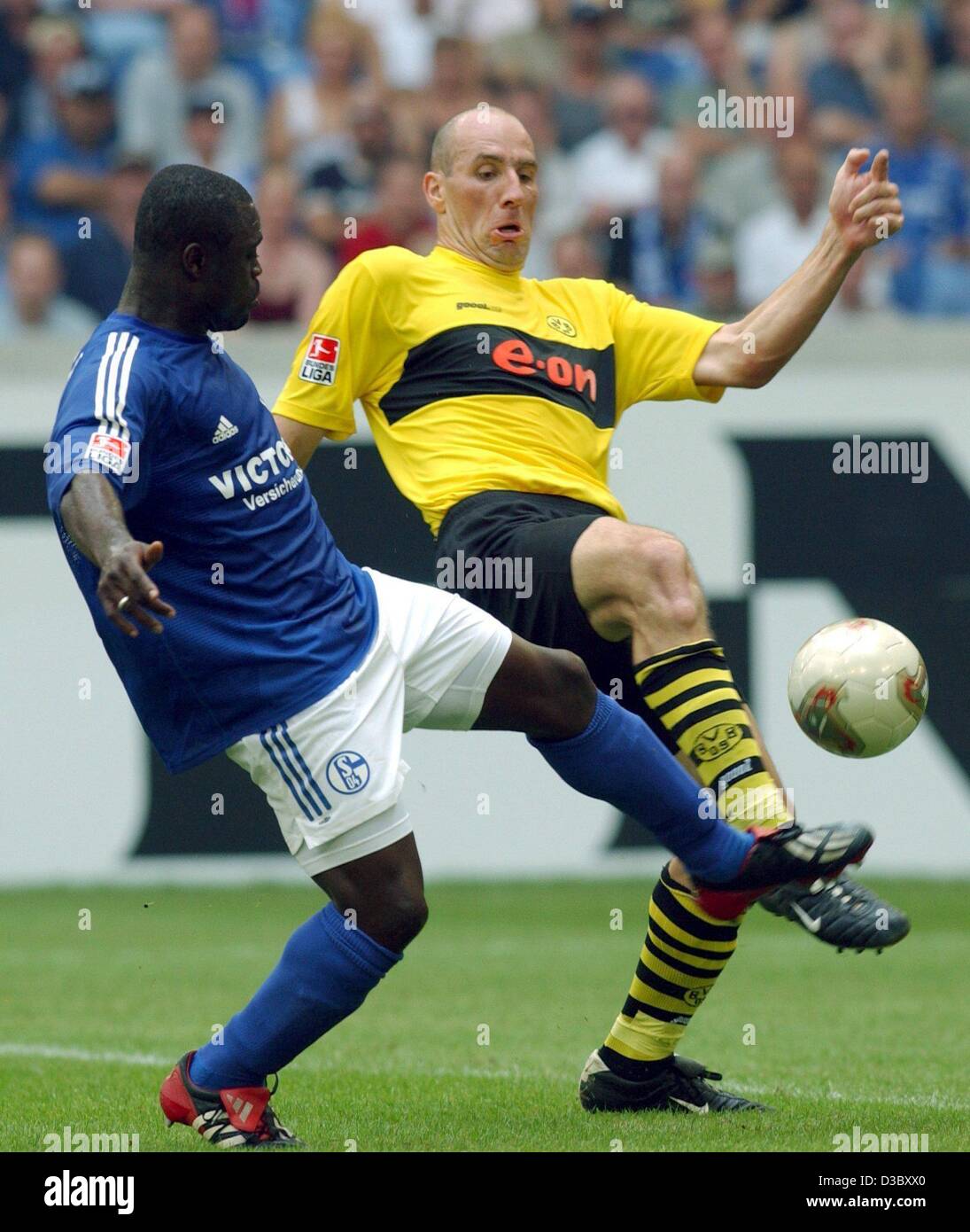 (Dpa) - Schalke di avanti Gerald Asamoah (L) il sistema VIES per la palla con Dortmund avanti ceco Jan KOLLER (R) durante il primo turno della Bundesliga contrapposte di gioco FC Schalke 04 e Borussia Dortmund a Gelsenkirchen, Germania, 2 agosto 2003. La partita si è conclusa in un 2-2 a. Foto Stock