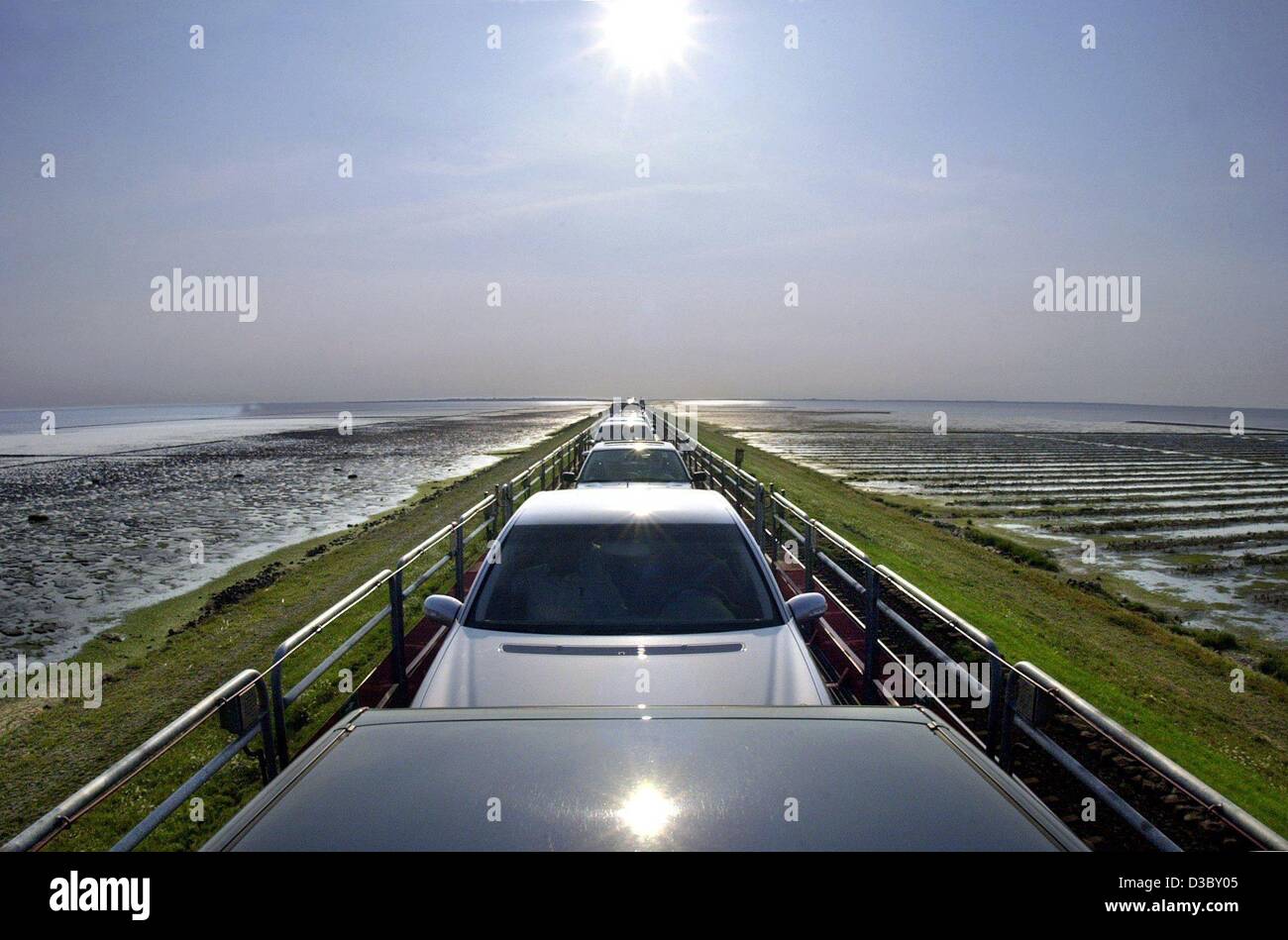 (Dpa) - Il sole si riflette sul tetto di una vettura che circola su SyltShuttle, una linea di relazioni lungo la diga di Hindenburg che collega la terraferma e l'isola di Sylt nel Mare del Nord, Germania, 29 luglio 2003. Il viaggio da Niebuell sulla terraferma a Westerland a Sylt dura circa 40 m Foto Stock