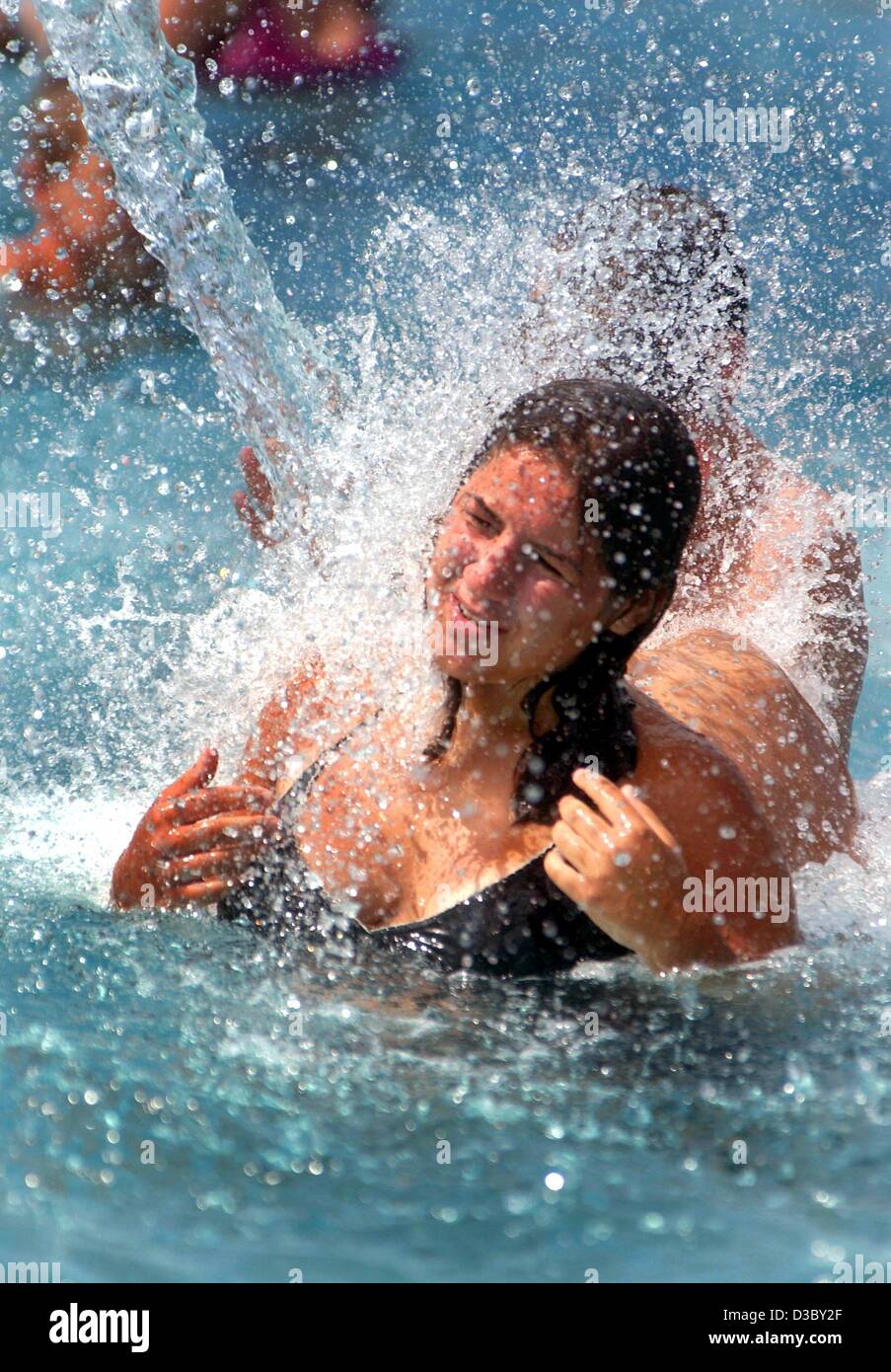 (Dpa) - Una donna si raffredda sotto una cascata artificiale in una piscina pubblica in Pankow, Berlino, 1 agosto 2003. Un ondata di calore di oltre 40 gradi centigradi in previsione per la Germania sudoccidentale. Foto Stock