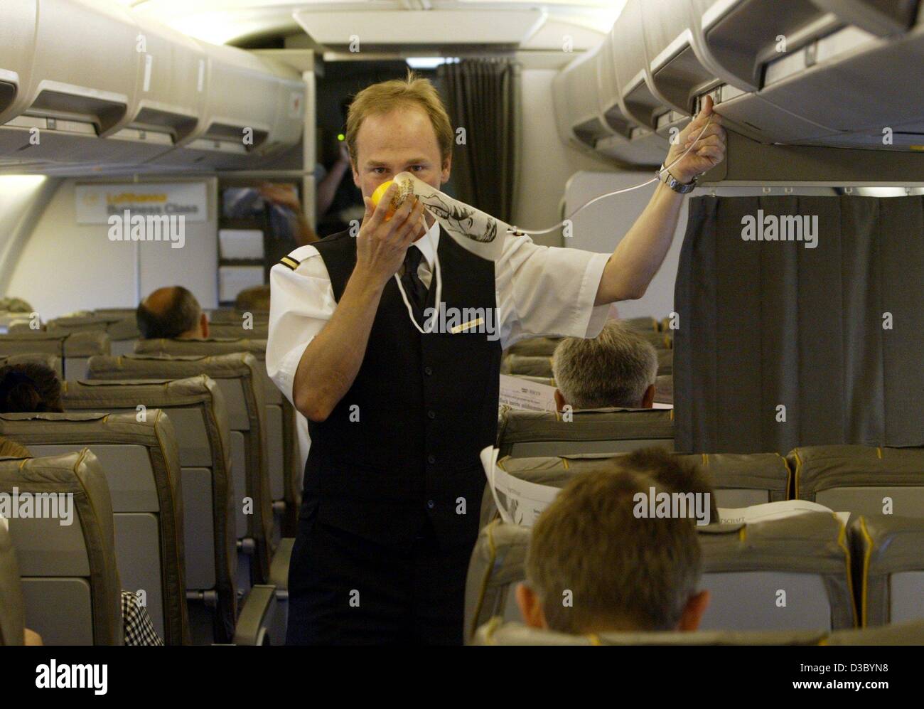 (Dpa) - un economo della Deutsche Lufthansa compagnia aerea passeggeri dà istruzioni di sicurezza e mostra come applicare una maschera ad ossigeno all'inizio di un volo da Dessau, Germania, 17 luglio 2003. Foto Stock