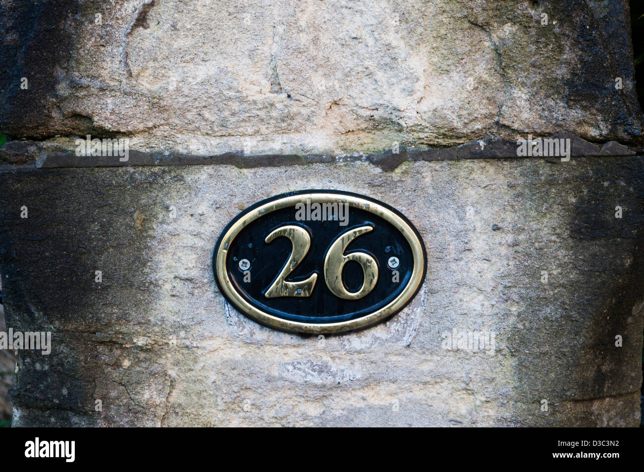 Numero 26 avvitata ad una porta di pietra post. Foto Stock