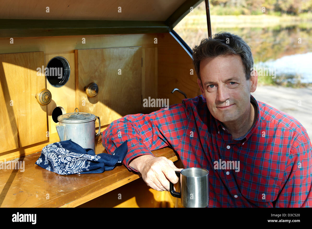 Uomo di mezza età di bere il caffè al campeggio Foto Stock