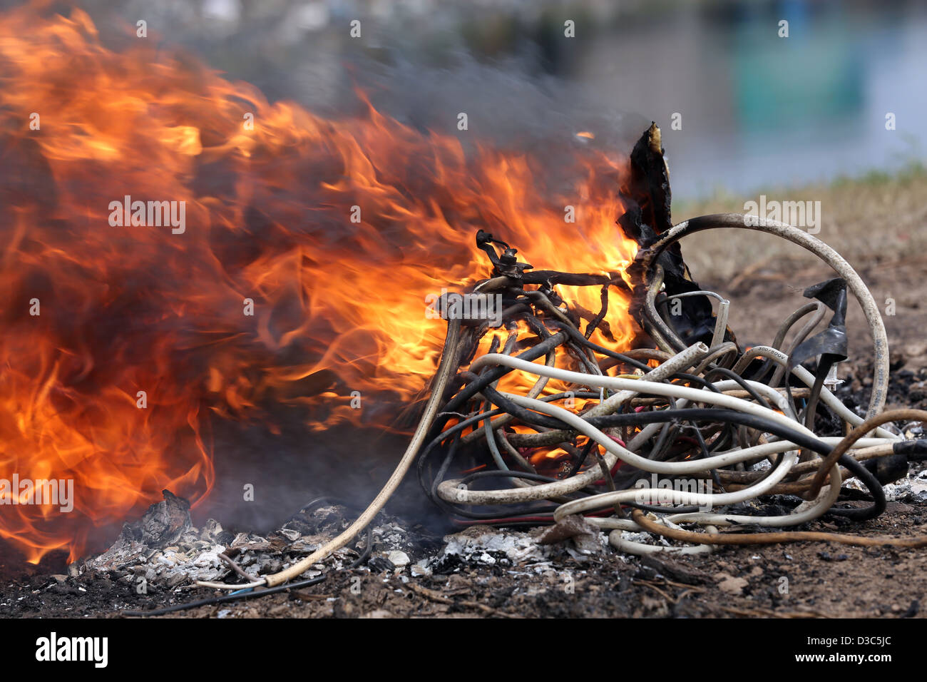 Bruciando i cavi dal computer e altri dispositivi elettronici per recuperare il rame nei pressi della baraccopoli di Agbogbloshie di Accra, in Ghana Foto Stock