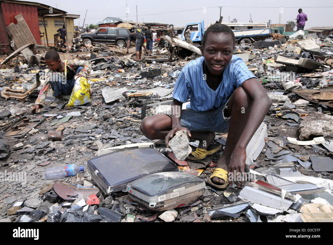 Ragazzi adolescenti smantellare i computer e gli altri dispositivi elettronici per recuperare il rame nei pressi della baraccopoli di Agbogbloshie di Accra, in Ghana Foto Stock