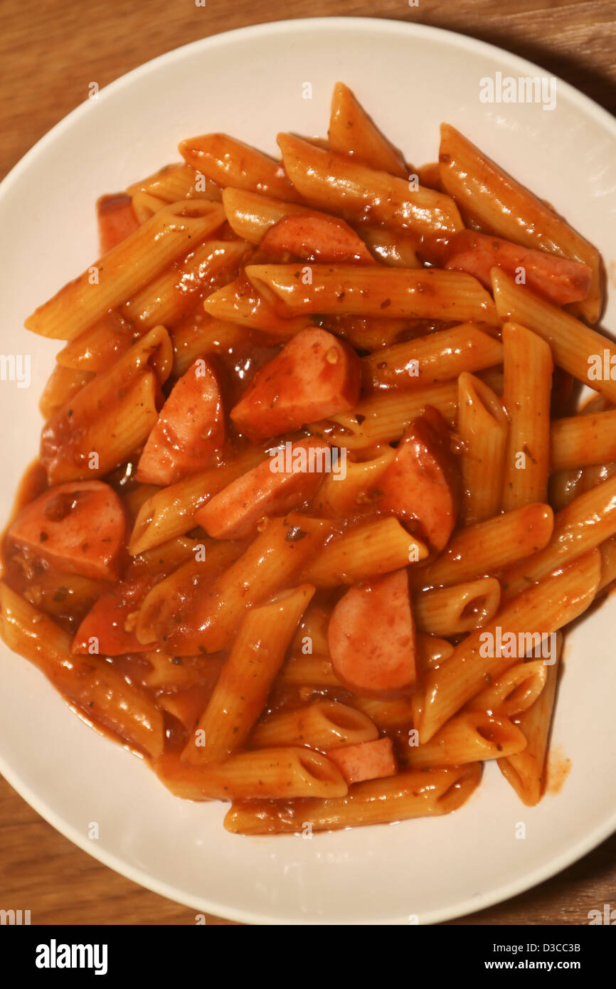 Penne la pasta nella ciotola con il sugo di pomodoro e salsiccia piccante Foto Stock