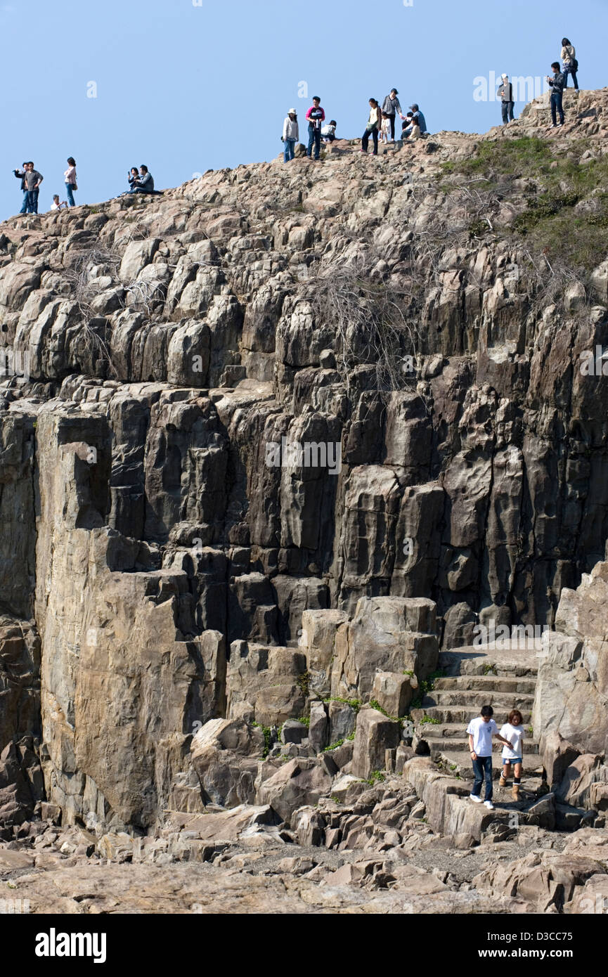 Giornata di sole turisti godendo la vista dalla cima della frastagliata e rocciosa costa sul Mare del Giappone vicino Tojimbo, Fukui, Giappone. Foto Stock