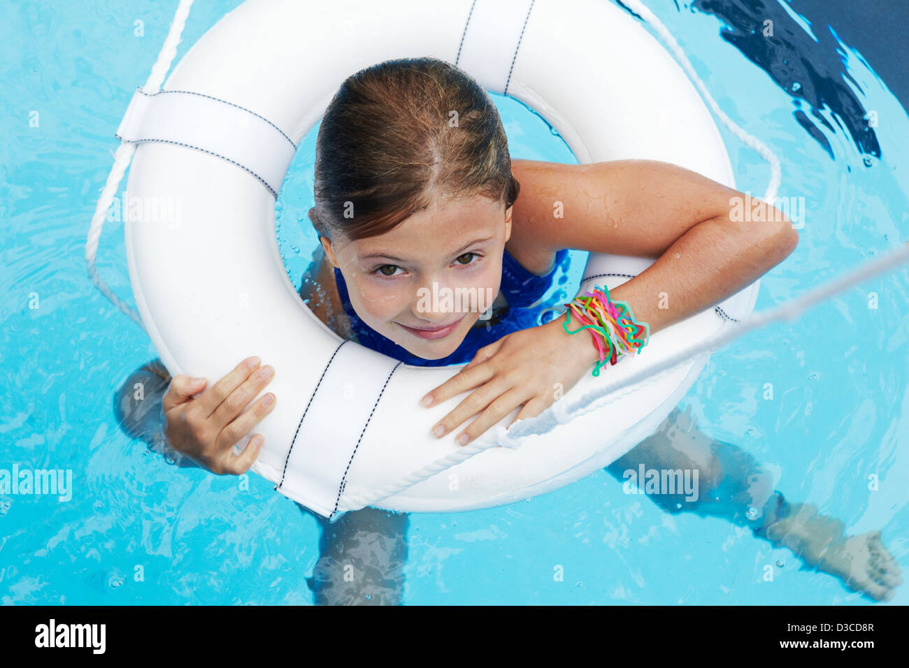 7 anno vecchia ragazza di nuoto in piscina con salvagente Foto Stock
