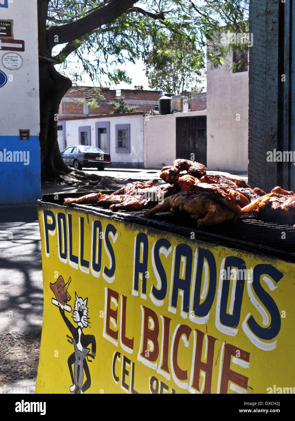 Delizioso pollo alla griglia di polli per la vendita al di fuori al cortile d'ingresso con piacevoli vie visibile al di là di Oaxaca Messico Foto Stock