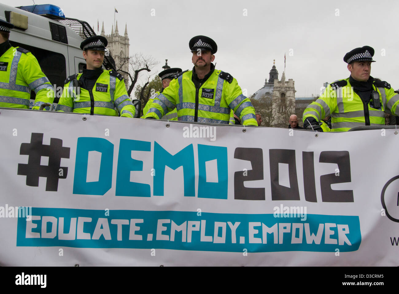 Quattro poliziotti di sostare dietro una barriera di protesta durante un corteo di studenti a Londra 2012 'DEMO 2012' in attesa di contestatori. Foto Stock
