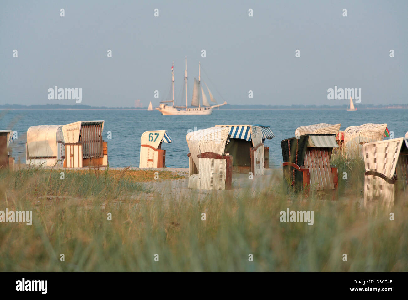 Spiagge, Germania, Strandkoerbe sulla spiaggia del Mar Baltico, in riva al lago un brigantino a tre alberi Foto Stock