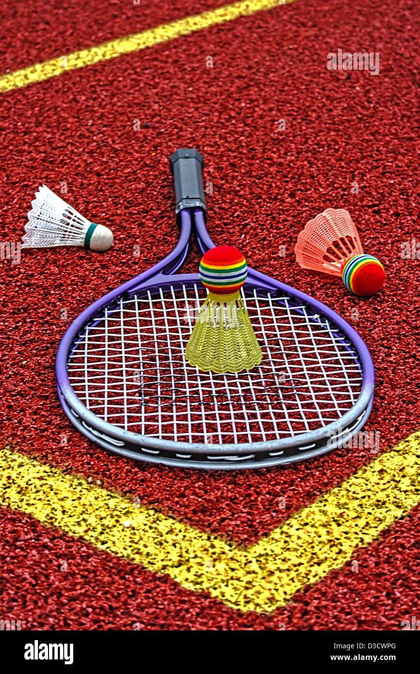 Badminton volani colorati e racket, posto in un angolo di un campo sintetico. Foto Stock